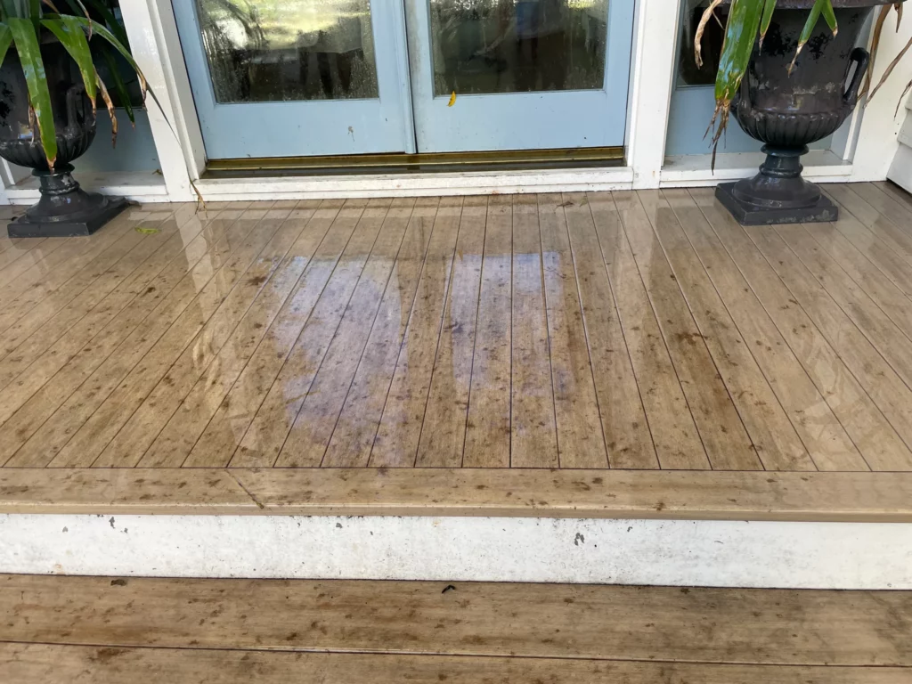 A dirty wood deck showing the results of a pressure washing before and after.