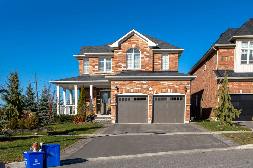 A two story brick house with a concrete driveway.