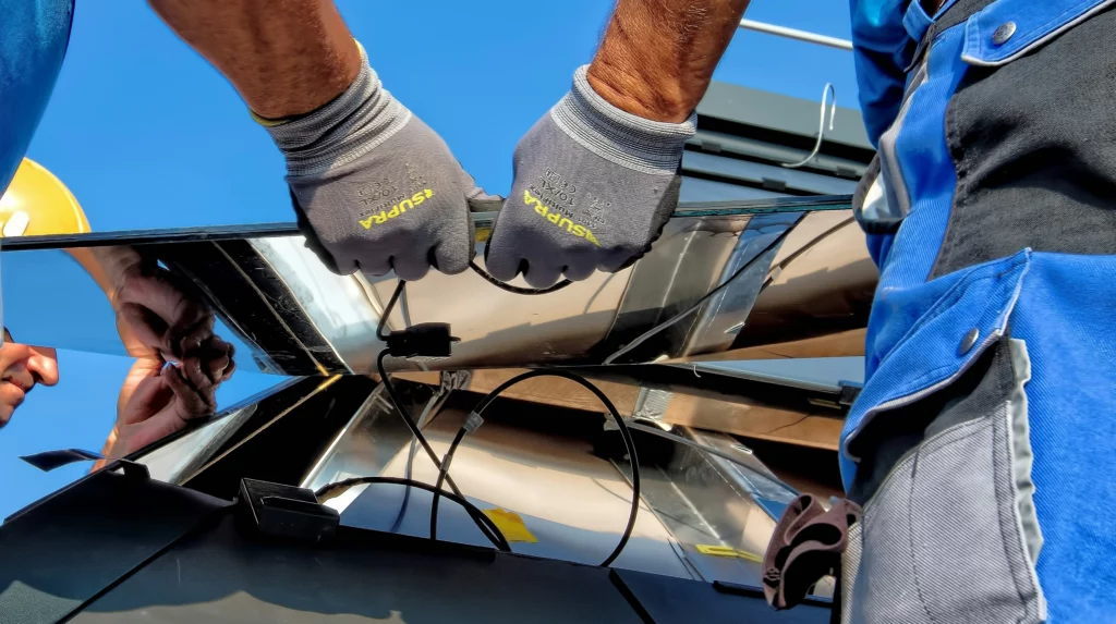 Two men installing a solar panel after pressure washing solar panels.