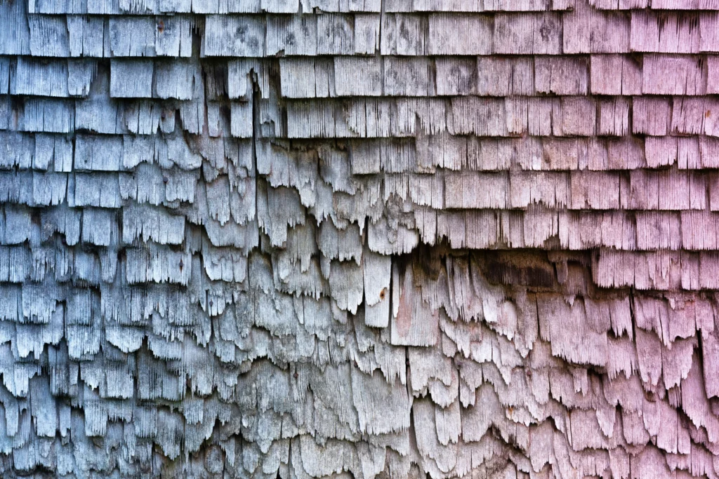 A roof with wooden shingles that are damaged showing why it is important to know Can You Pressure Wash a Roof.