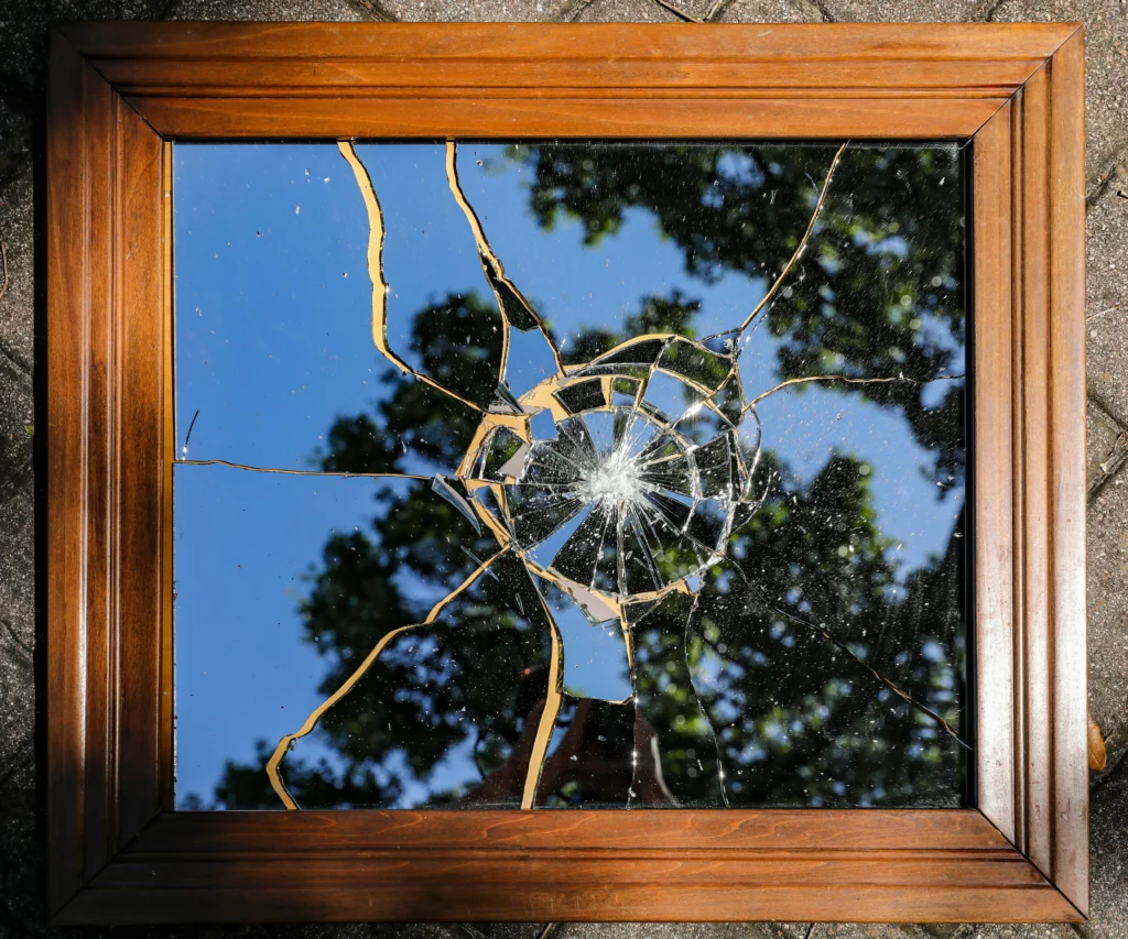 A broken mirror representing the damage that can happen to glass windows.