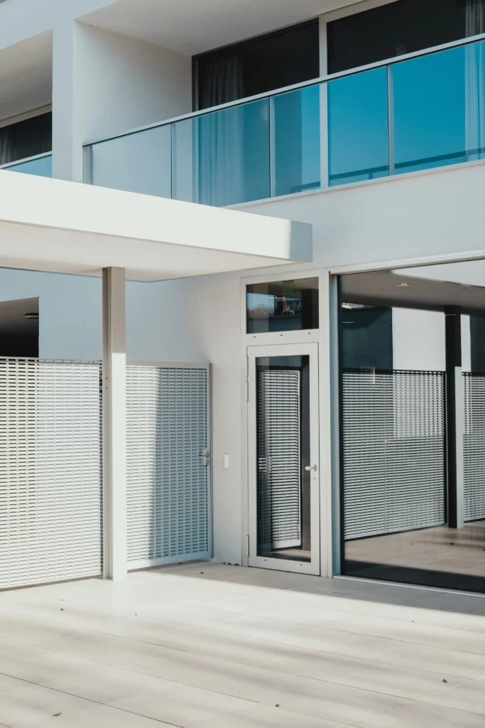 The exterior of a modern house with a door with a transom window.