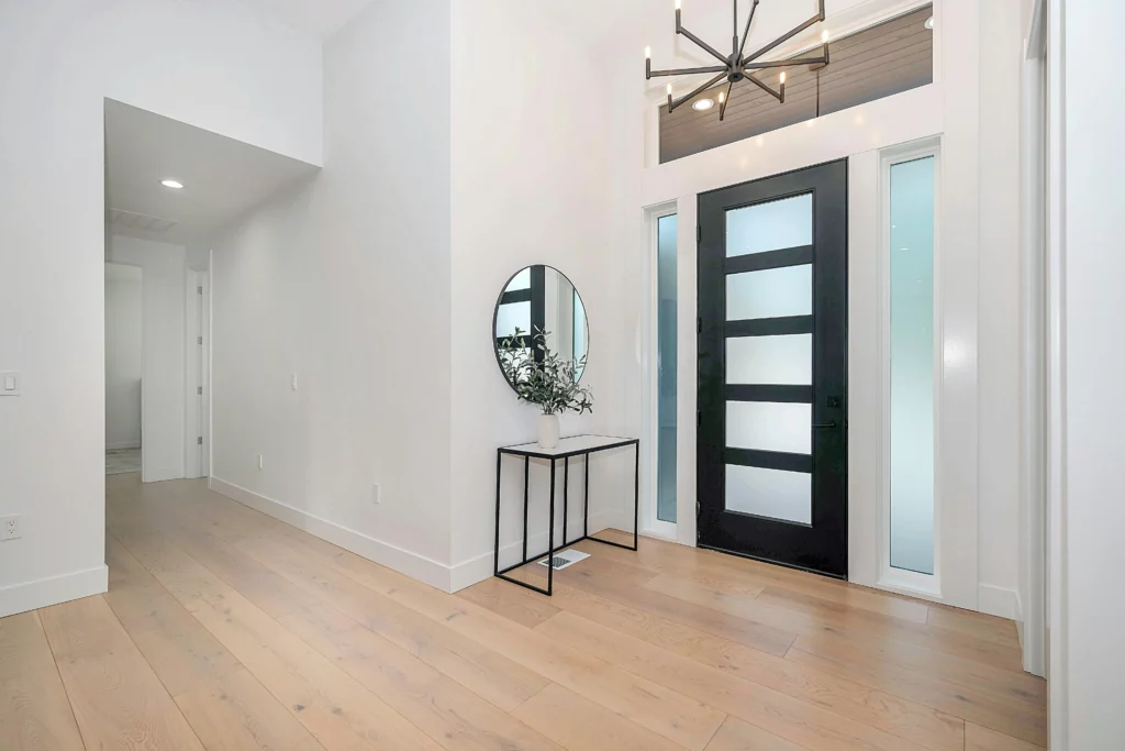 A modern white home's entry way showing a transom window.