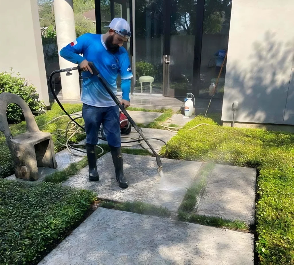 most expensive home repairs - a man pressure washing a patio paver.