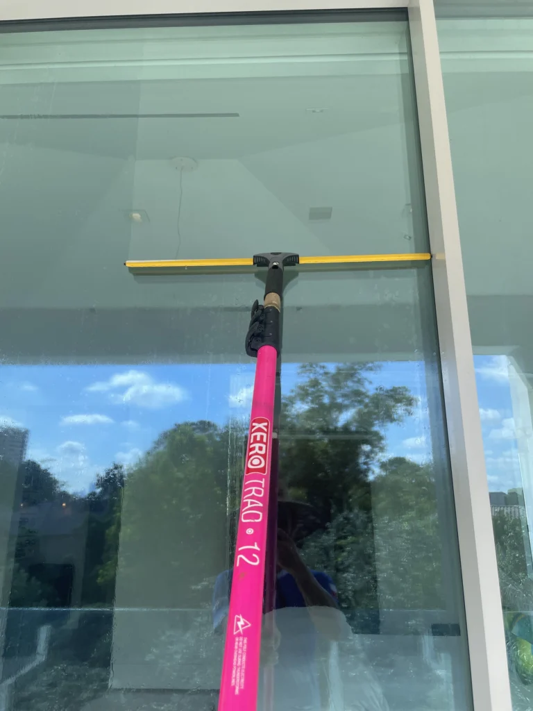 Garage Door Windows - long pink squeegee being used to clean window