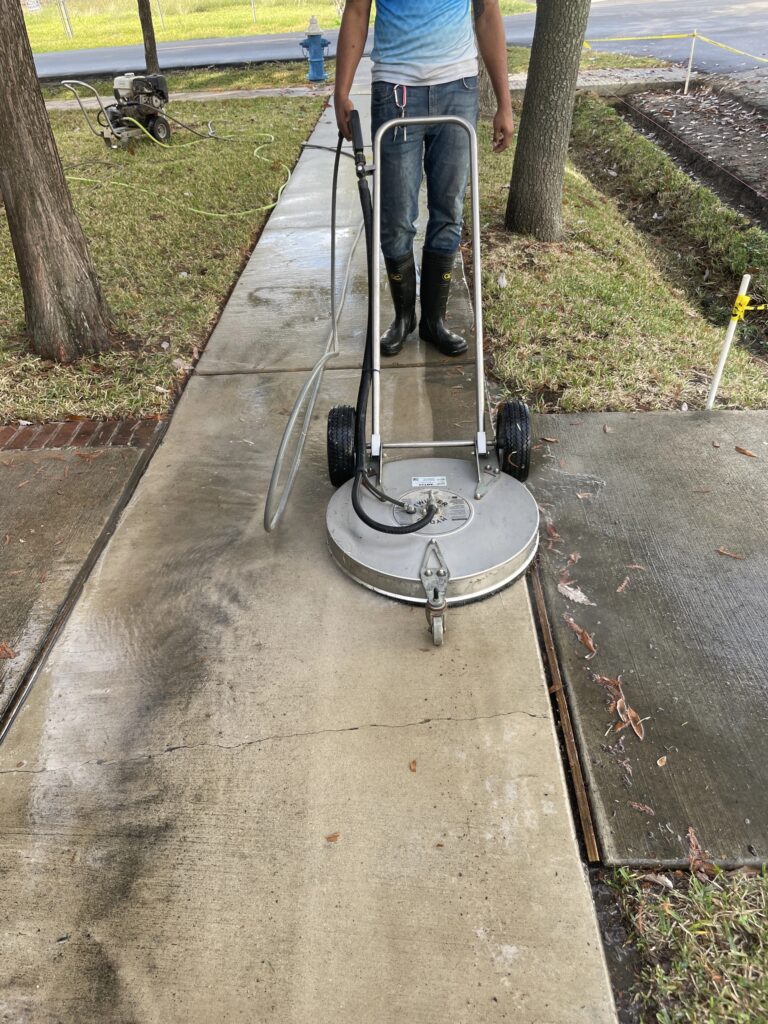 Man Using a Pressure Washer Surface Cleaner on Sidewalk