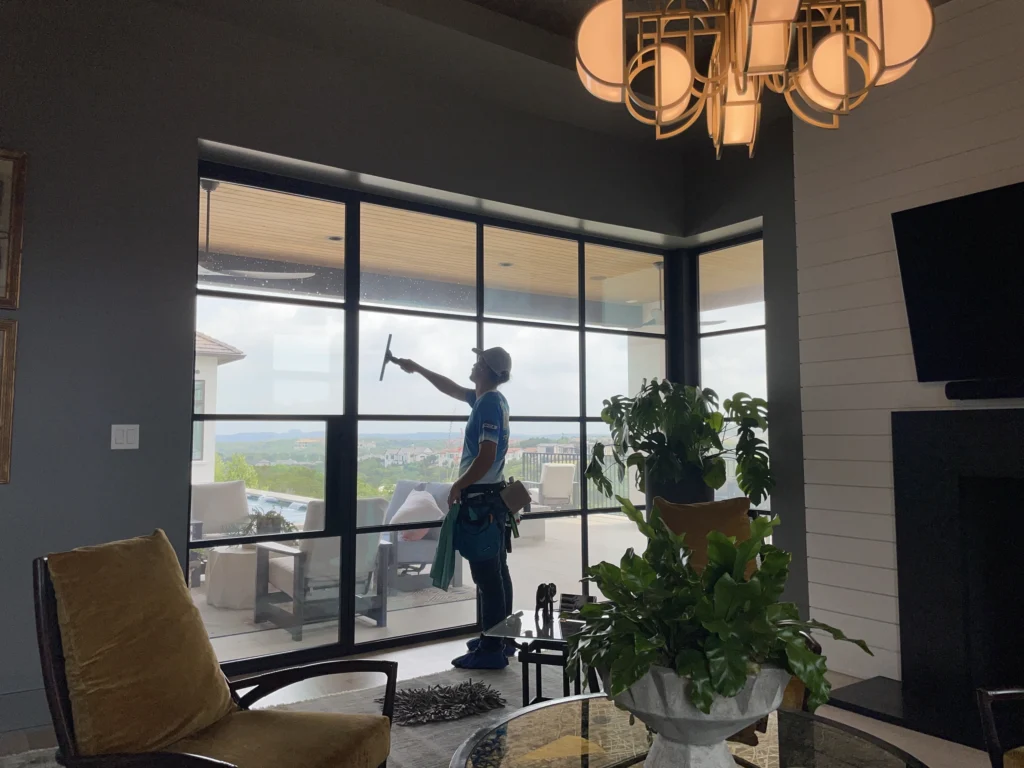 Man Cleaning Indoor Side of Windows in Home