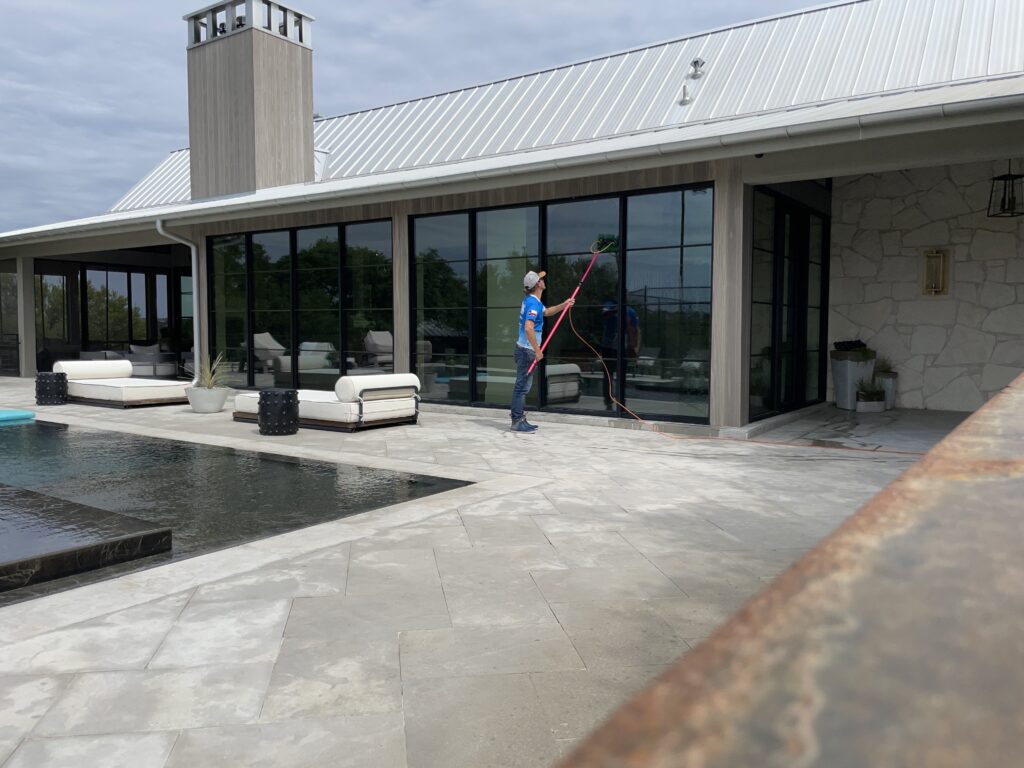 Man Cleaning Exterior Glass Doors in Backyard